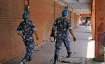 Jaipur: Rapid Action Force personnel walk past closed shops