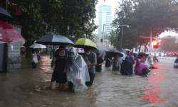 People move through flood water after a heavy downpour in