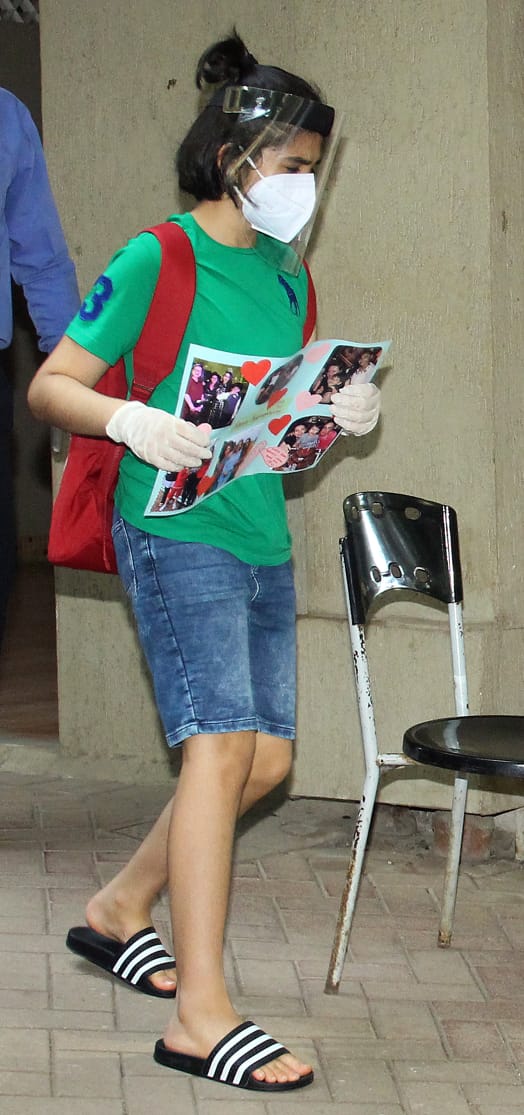 Karisma Kapoor's son Kiaan carries a handmade photo card to Kareena Kapoor's home. He can be seen wearing a green coloured t-shirt & blue shorts. 