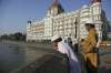 Two boys stand outside the iconic Taj Mahal Palace hotel,