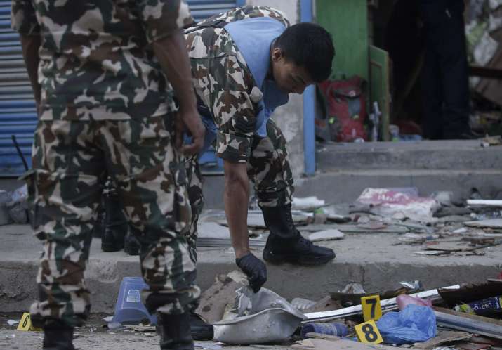 Nepalese army personnel examine the site of an explosion in